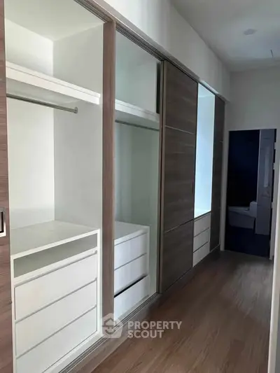 Spacious walk-in closet with modern sliding doors and ample storage space.