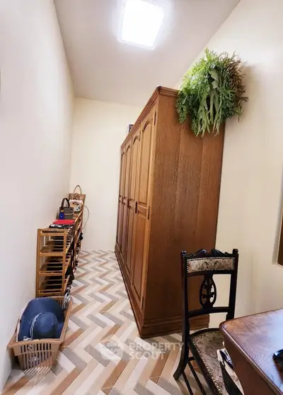 Charming storage room with elegant wooden wardrobe and stylish chevron flooring.