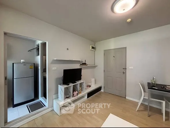Modern living room with sleek furniture and open kitchen layout in a stylish apartment.