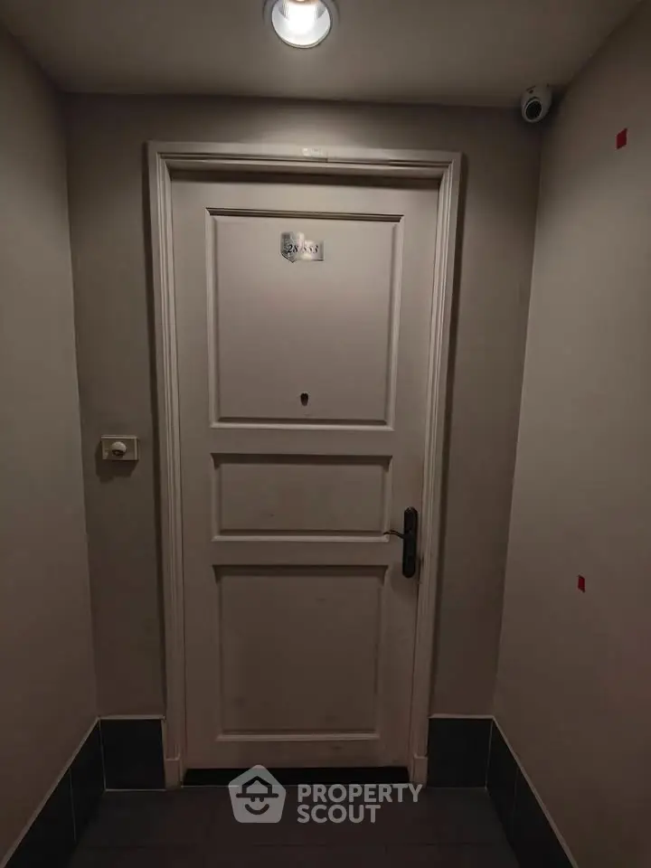 Secure apartment entrance with modern door and surveillance camera