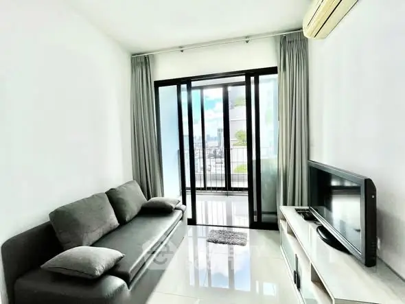 Modern living room with sleek sofa and balcony view in a bright apartment.