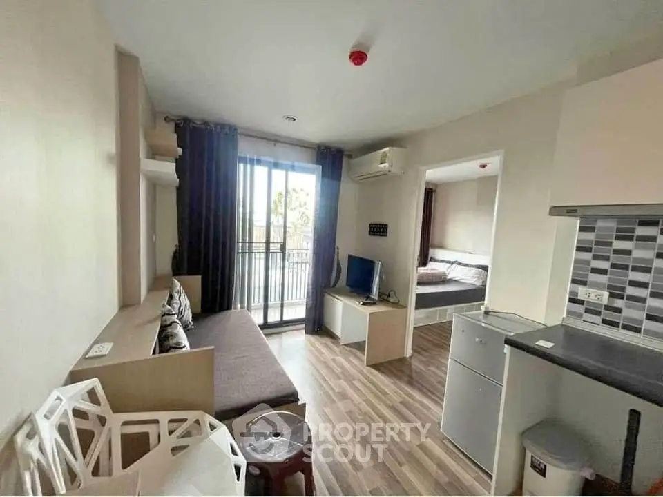 Modern studio apartment with open layout and balcony access, featuring stylish decor and natural light.