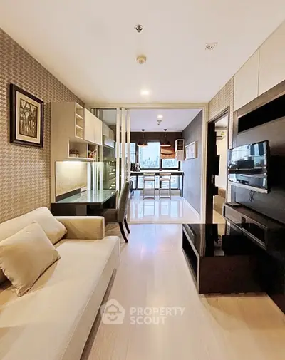 Modern living room with open layout leading to a stylish kitchen, featuring elegant decor and ample natural light.