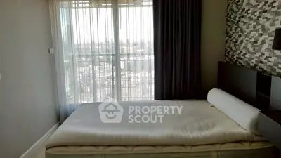 Cozy bedroom with modern decor and large window offering city view