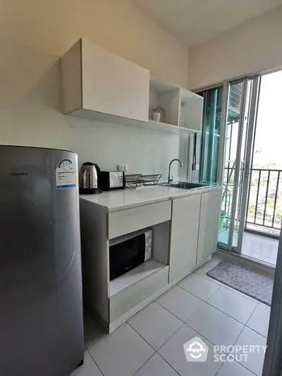 Modern compact kitchen with balcony access and sleek appliances