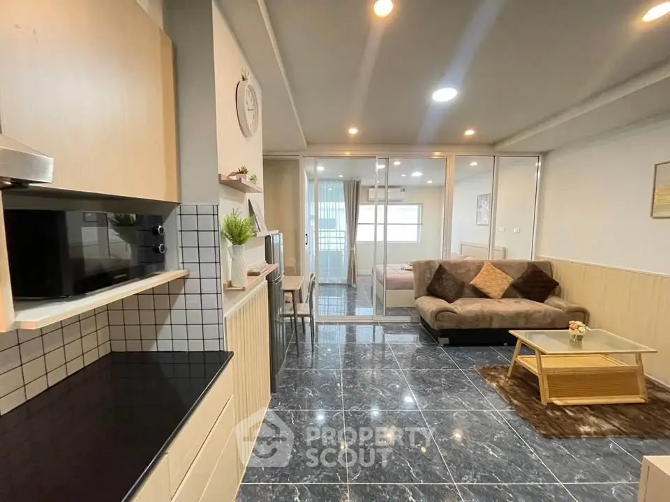 Modern open-plan living room with sleek kitchen and cozy seating area