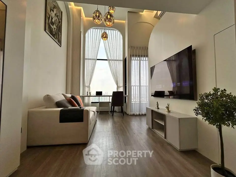 Modern living room with high ceilings, large window, and stylish decor