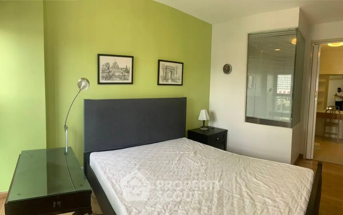 Cozy bedroom with green accent wall and modern furnishings