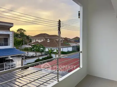 Charming balcony view overlooking suburban neighborhood at sunset, perfect for relaxation.