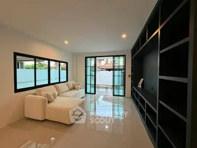 Spacious modern living room with large windows and sleek shelving