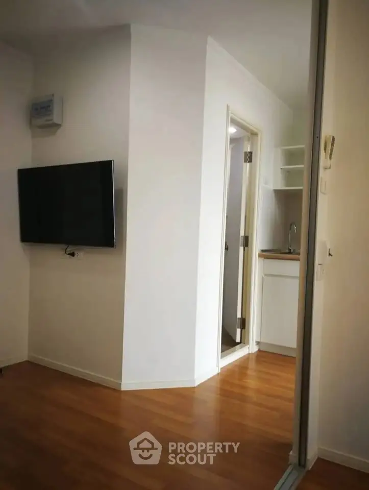 Modern apartment interior with wooden flooring and wall-mounted TV