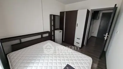 Modern bedroom with sleek furniture and hardwood floors in a contemporary apartment.