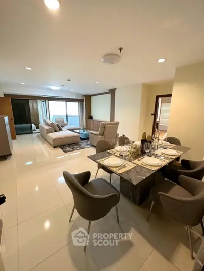 Spacious modern living and dining area with elegant furniture and bright lighting.