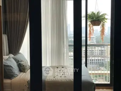 Luxurious bedroom with balcony offering stunning city views and elegant decor.