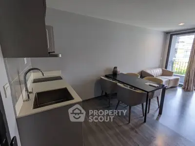 Modern open-plan kitchen and living area with sleek design and balcony view.