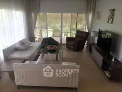 Spacious living room with modern furniture and garden view, perfect for relaxation and entertainment.