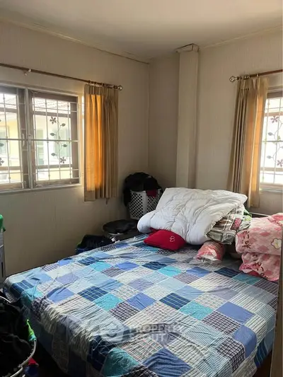 Cozy bedroom with natural light and comfortable bedding in a well-lit space.