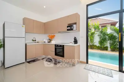 Modern kitchen with pool view, featuring sleek appliances and open layout for seamless indoor-outdoor living.