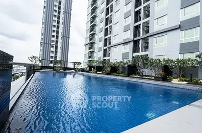 Modern apartment building with sleek design and poolside view, perfect for luxury living.