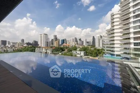Luxurious rooftop pool with stunning city skyline views in modern high-rise building.