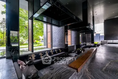 Luxurious modern living room with sleek design and large windows overlooking greenery.