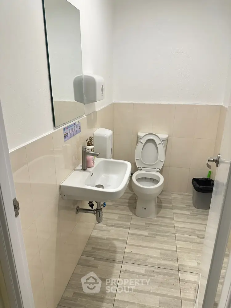Compact bathroom with modern fixtures and neutral tiles