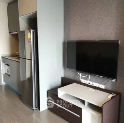 Modern apartment interior with sleek kitchen and wall-mounted TV