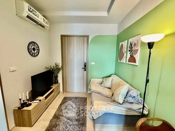 Cozy living room with modern decor, featuring a stylish sofa, wall art, and air conditioning.