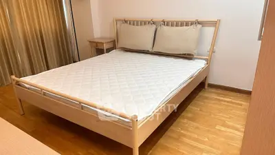 Spacious bedroom with wooden bed frame and cozy decor