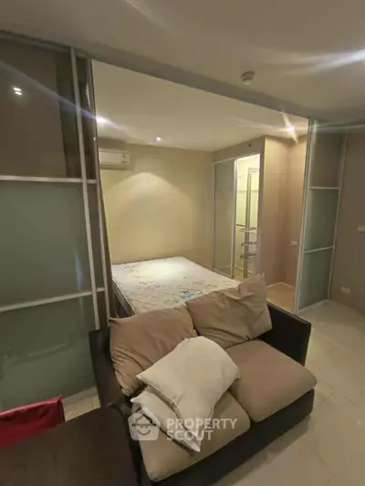 Cozy studio apartment with modern sliding doors and comfortable sofa, perfect for urban living.