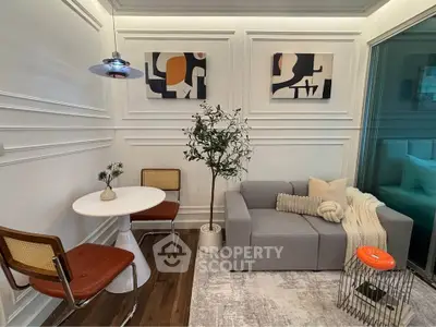 Stylish modern living room with cozy sofa, chic decor, and elegant wall art in a compact space.