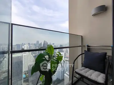 Stunning high-rise balcony with panoramic city view and cozy seating area.