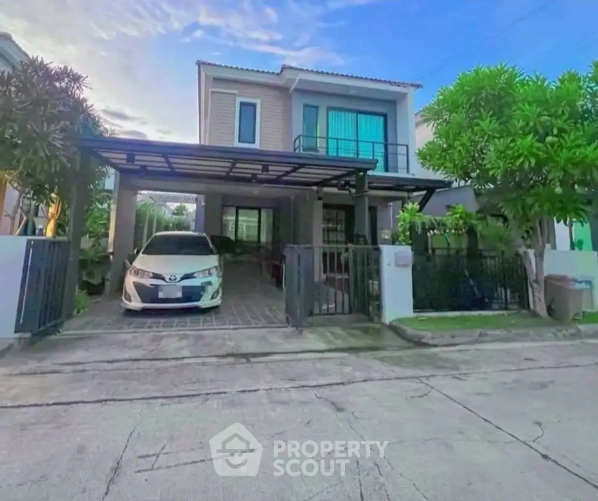 Modern two-story house with carport and lush greenery