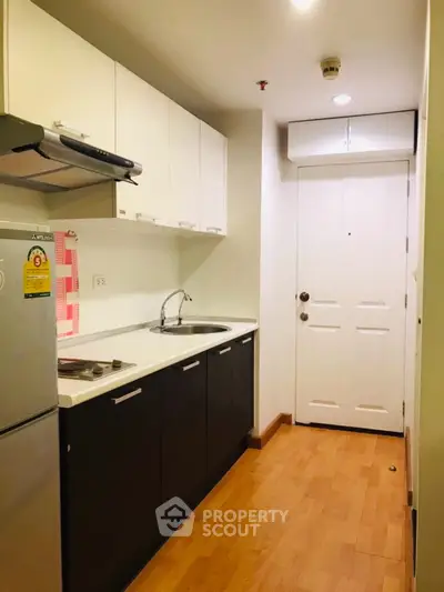 Modern compact kitchen with sleek cabinets and wooden flooring