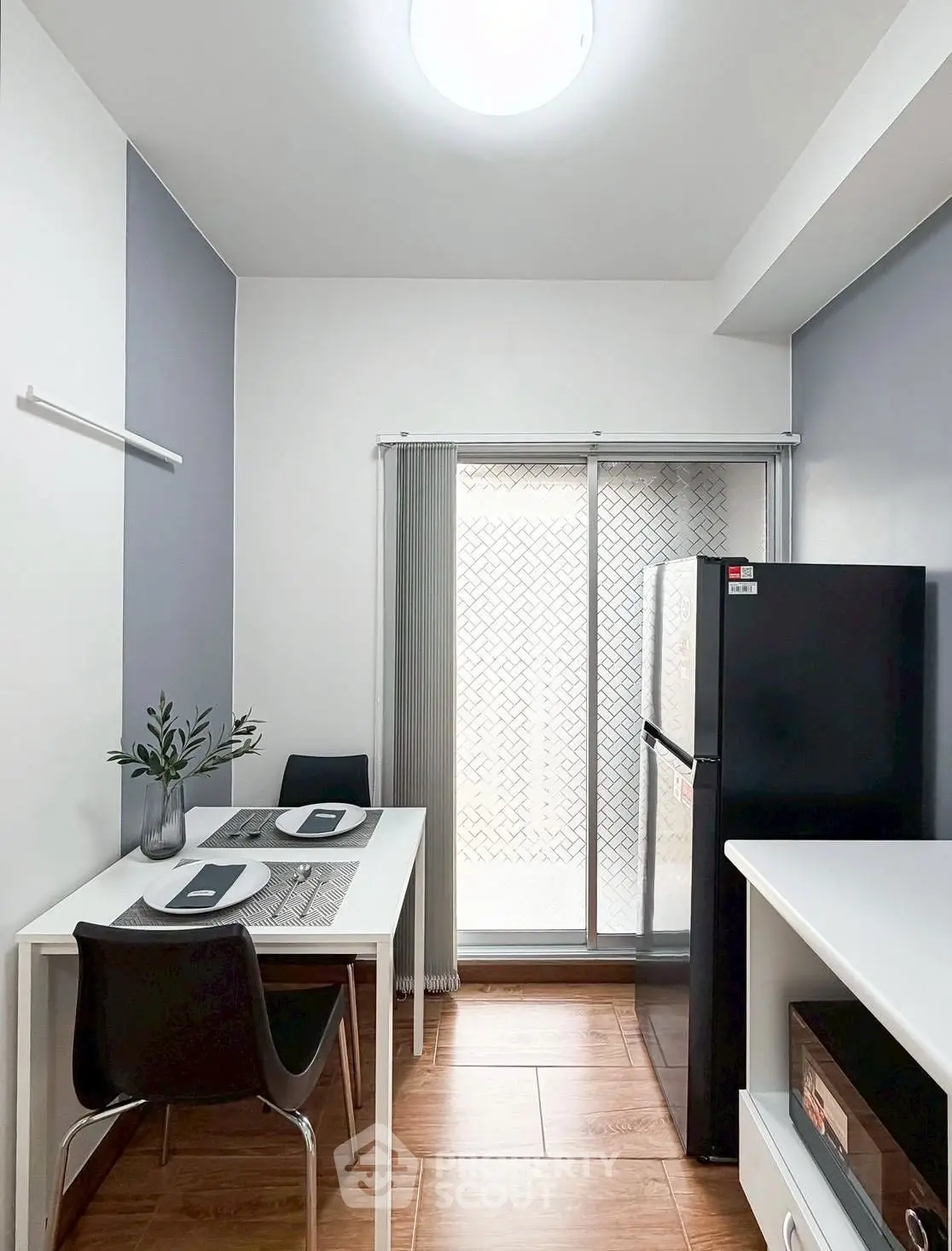 Modern kitchen with sleek black fridge and dining area