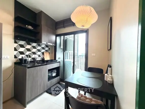 Modern kitchen with open layout and stylish backsplash in compact apartment.