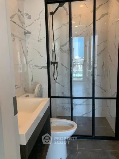 Modern bathroom with sleek shower and marble tiles, perfect for luxury living.