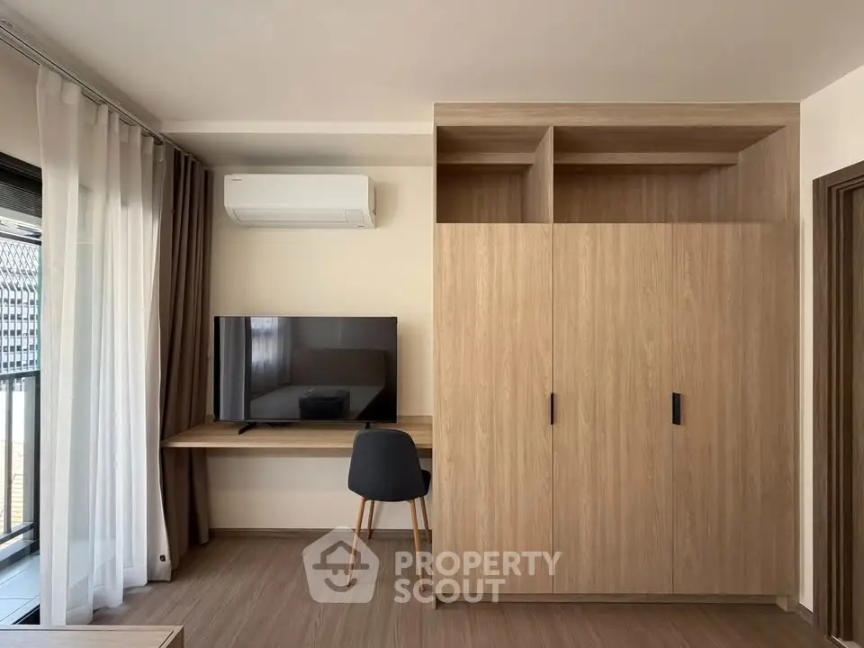 Modern living room with wooden furniture, TV, and air conditioning unit, perfect for cozy relaxation.