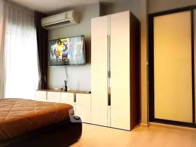 Modern bedroom with sleek wardrobe and wall-mounted TV, featuring a cozy ambiance and stylish decor.
