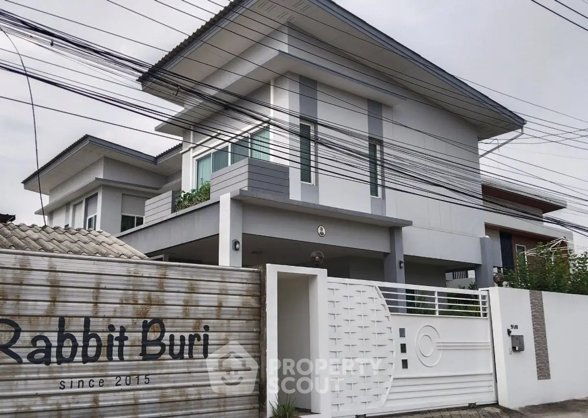 Modern two-story house with sleek design and gated entrance in Rabbit Buri community.