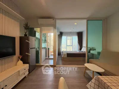Modern open-plan living room with kitchen and bedroom, featuring stylish decor and natural light.