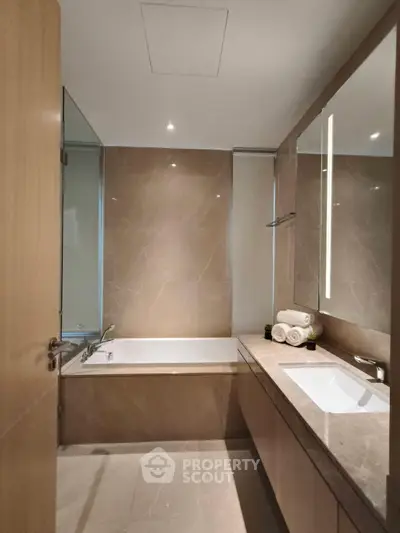 Luxurious modern bathroom with elegant marble finishes and sleek fixtures.