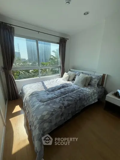 Bright and cozy bedroom with large window and modern decor in urban apartment.