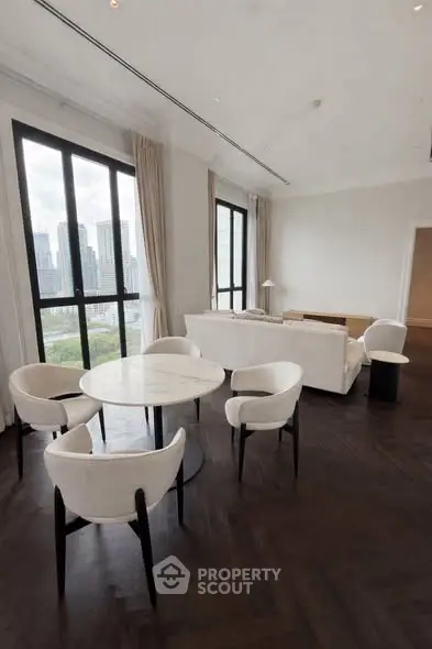 Luxurious living room with panoramic city views and elegant white furniture.