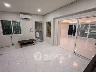 Spacious modern living room with marble flooring and large sliding glass doors