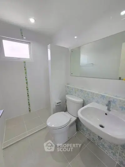 Modern bathroom with sleek fixtures and stylish tile design, featuring a spacious shower area.