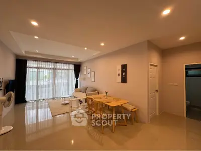 Spacious living room with dining area and large windows for natural light.