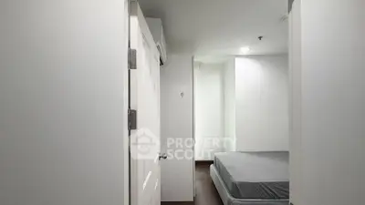 Minimalist bedroom with white walls and simple bed setup, perfect for a cozy living space.