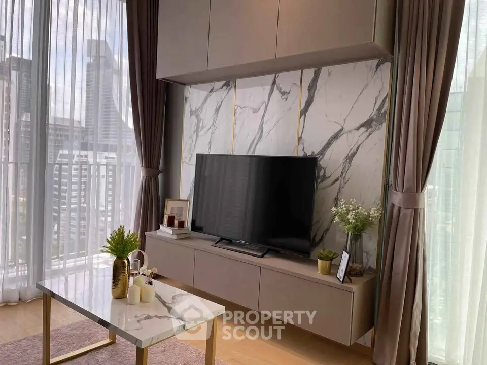 Luxurious living room with marble accents and city view, featuring modern TV setup and elegant decor.