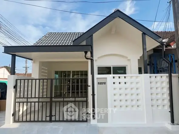 Charming single-story house with modern facade and gated entrance.